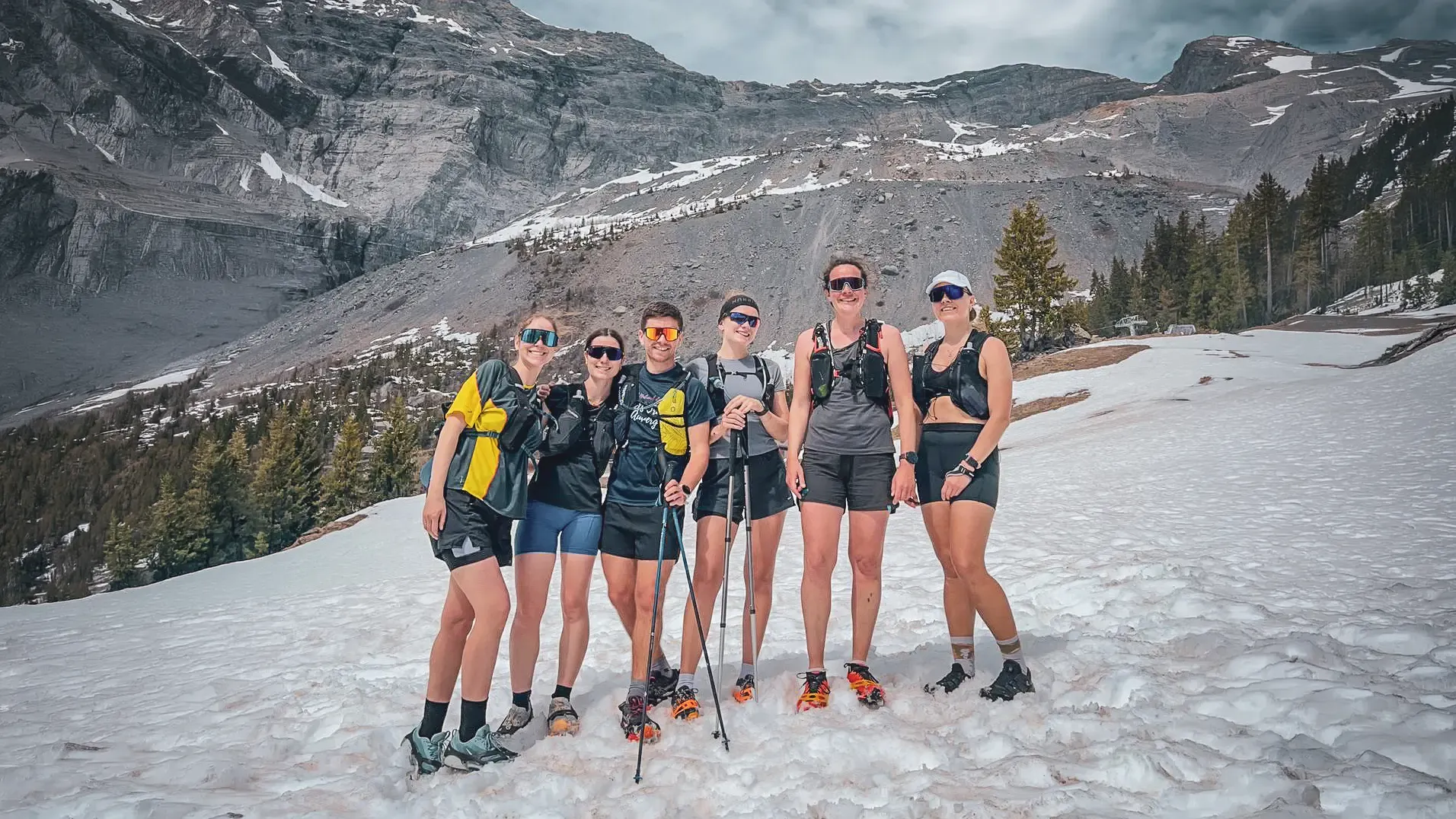 A group of mountain runners with the Mont-Blanc massif as a backdrop, in an adventurous atmosphere.