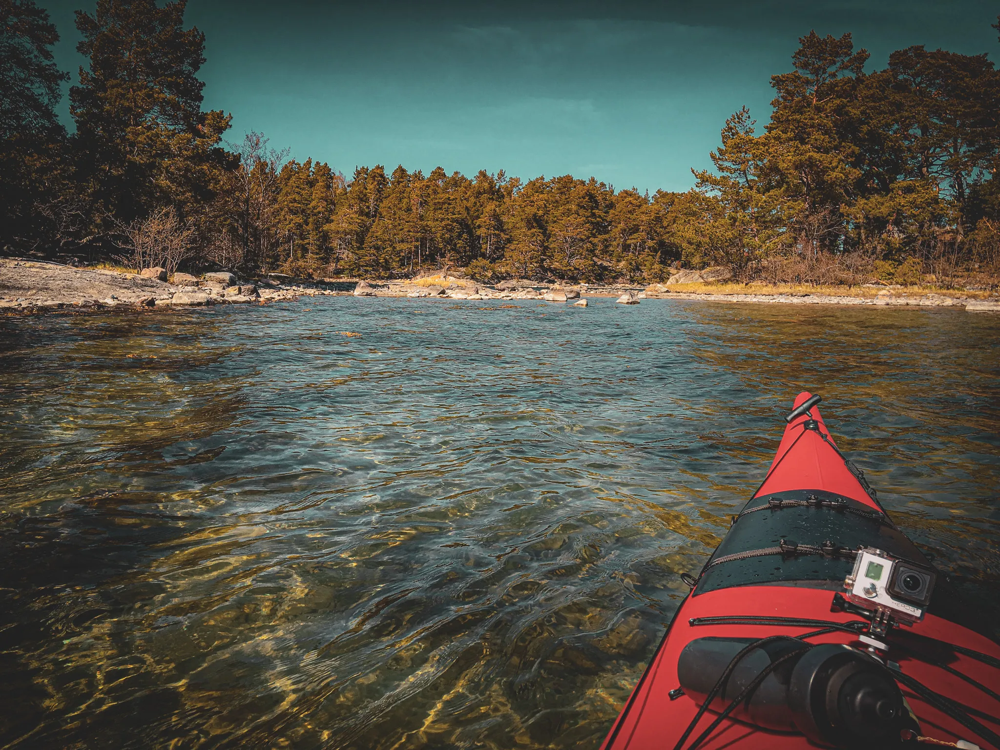 Red sea kayak on crystal-clear water in the Stockholm archipelago.