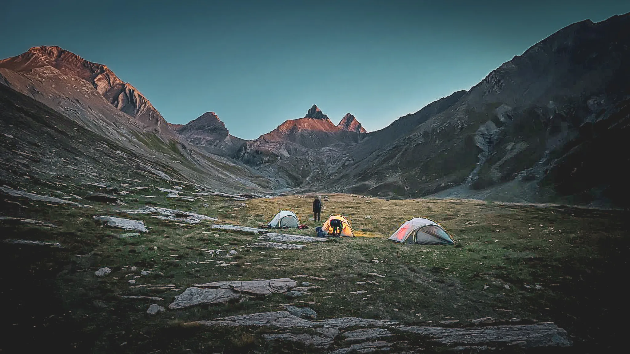 Alpenbivak onder de Aiguilles d'Arves, tenten verlicht in de schemering, tijdens de 4-daagse tocht met bivak.