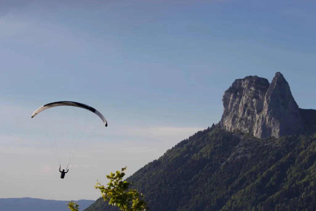 Homme en parapente à côté d'une montagne