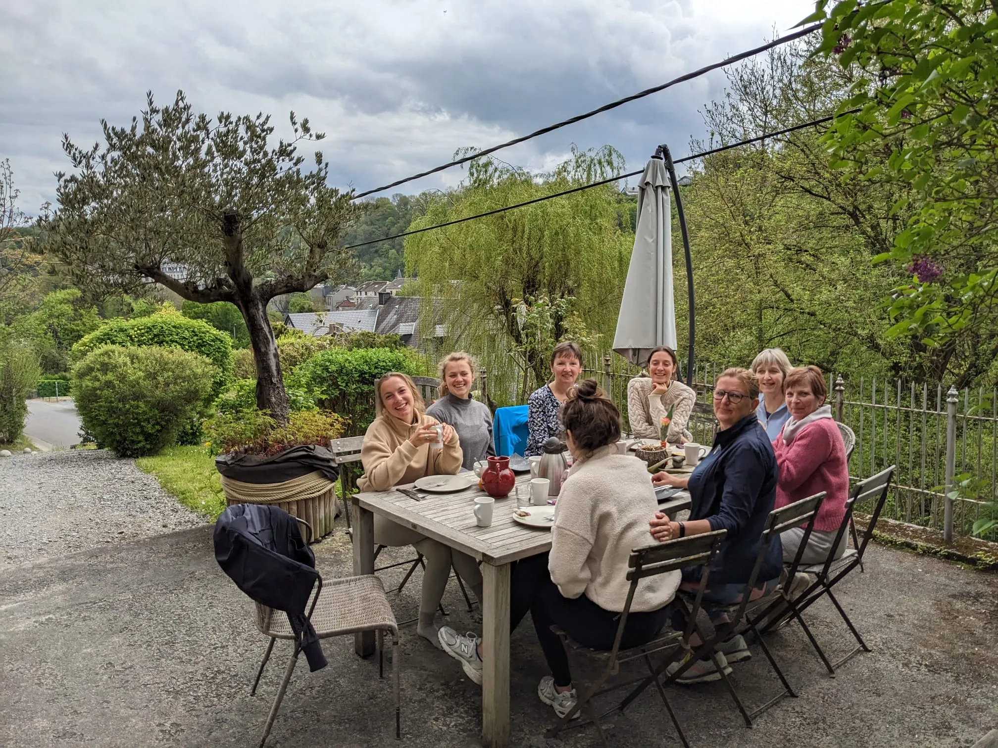 Smiling group around an outdoor table, a convivial moment in nature