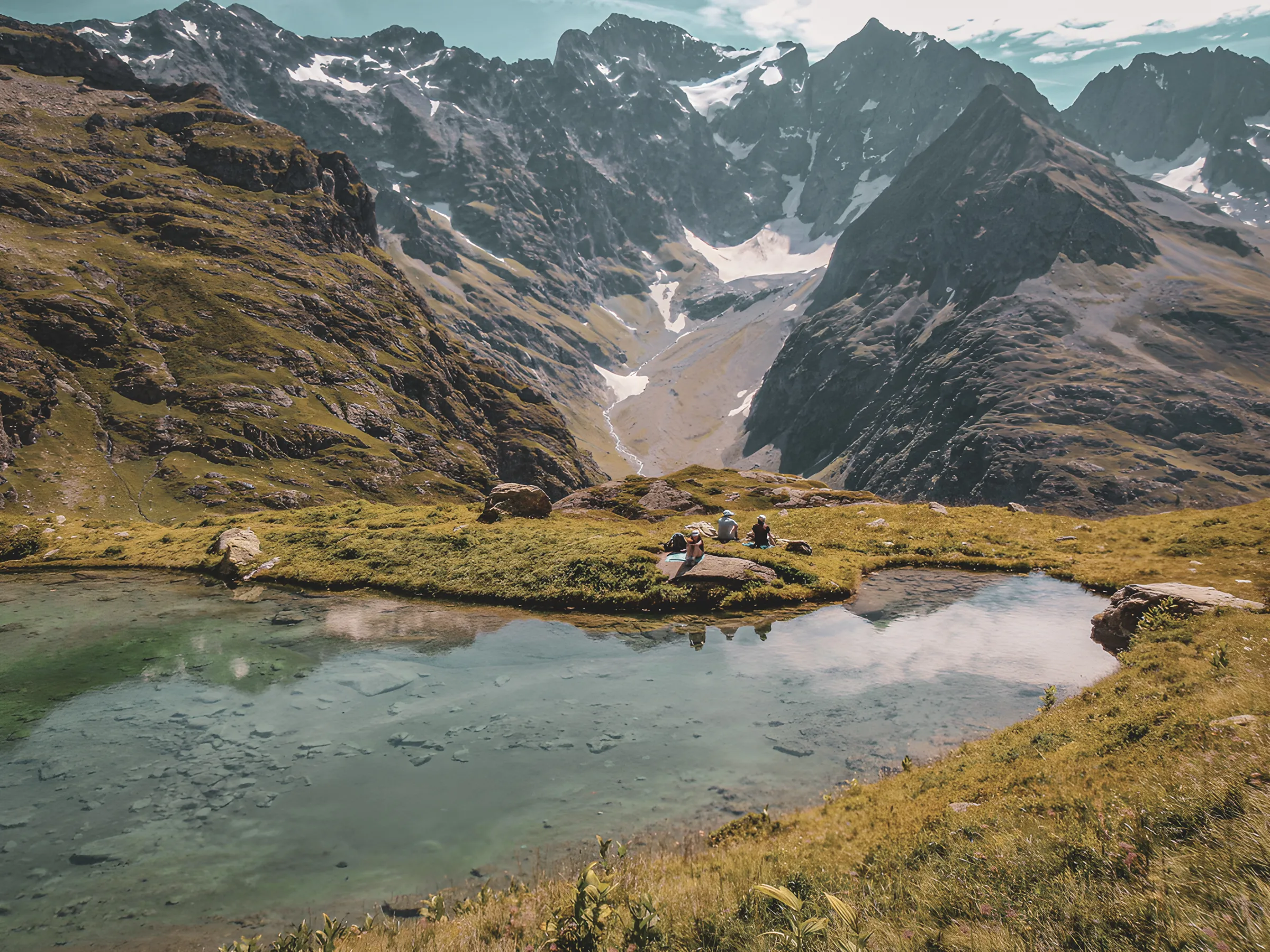 Groupe de randonneurs au repos près d'un lac d'altitude après une journée de marche