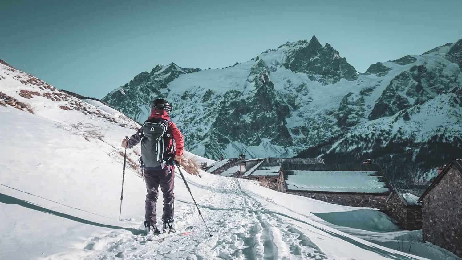 Ski tourer on a snowy route in La Grave, with mountains beyond.