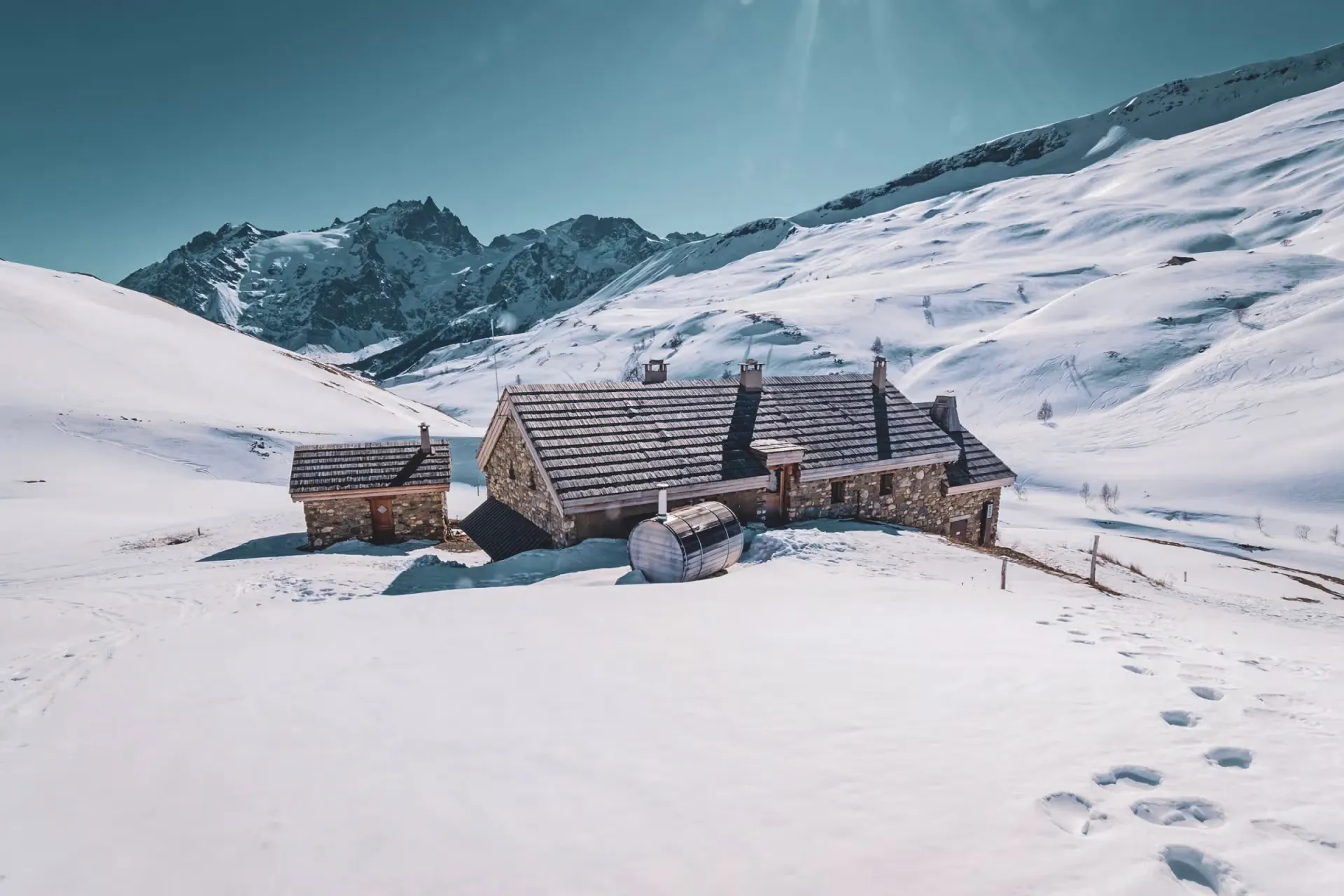 Stone mountain hut surrounded by snow in the mountains above La Grave.