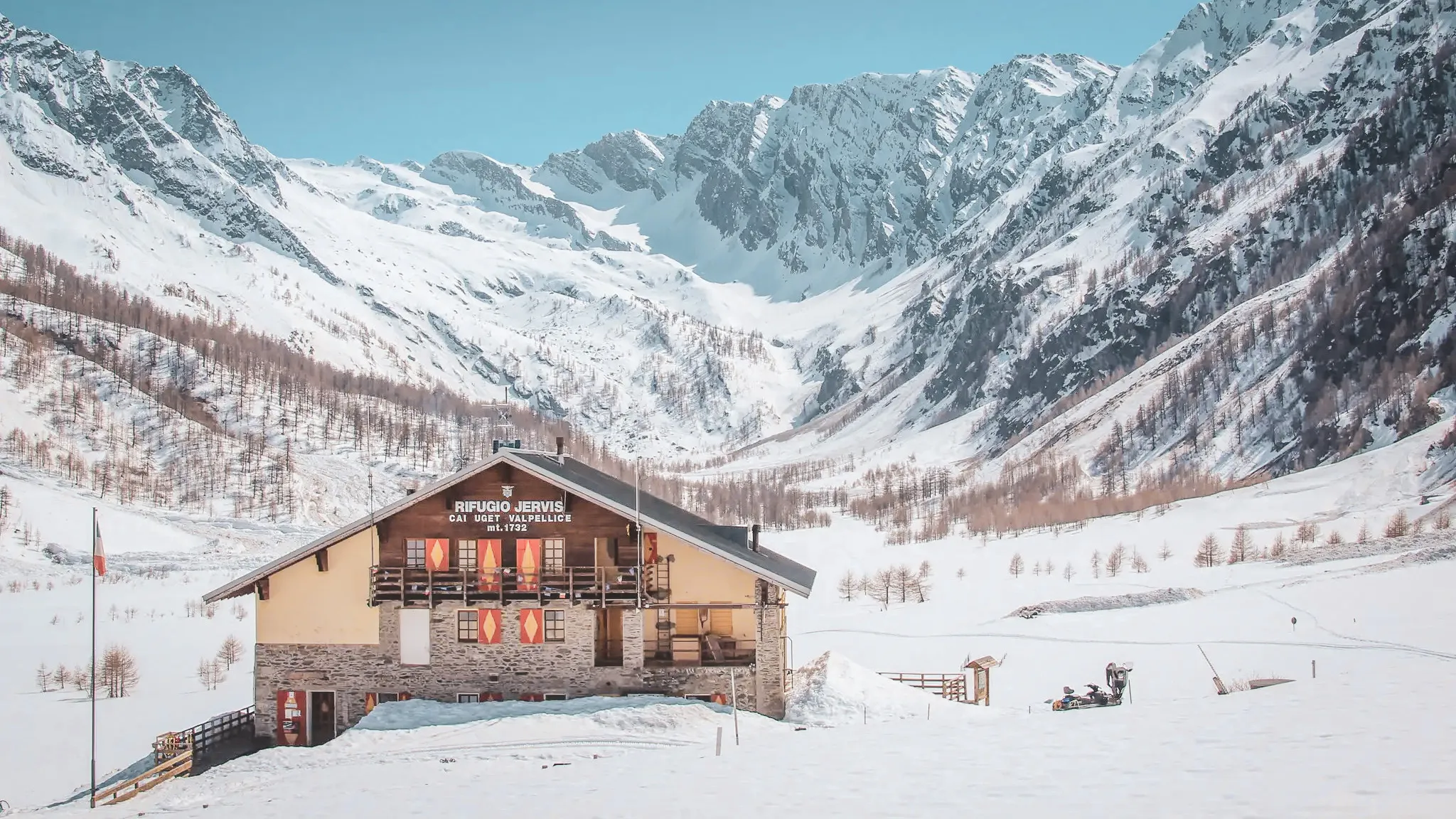 Berghut Willy Jervis omringd door besneeuwde toppen in de Italiaanse Alpen