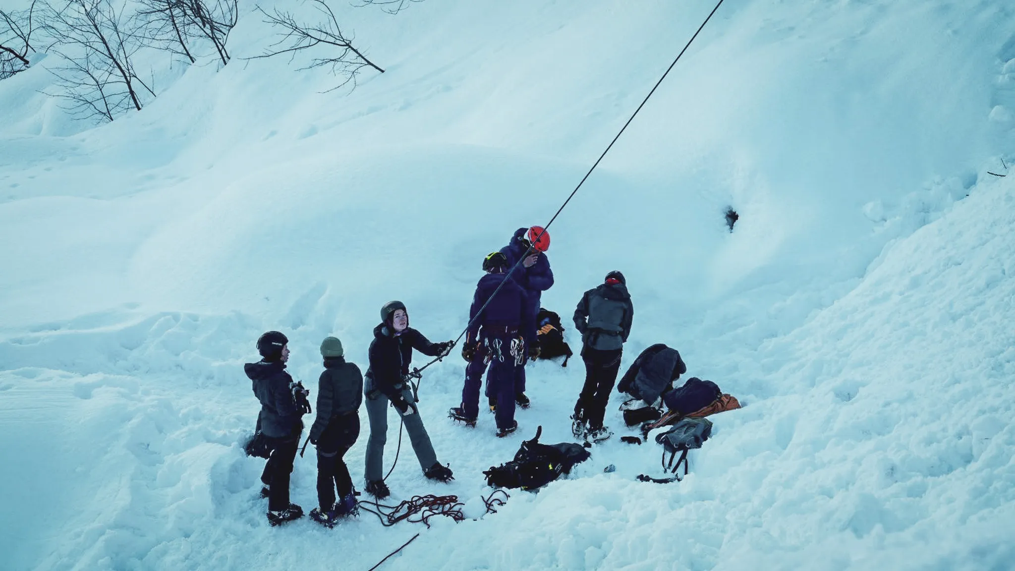 Initiatie ijsklimmen: een groep op een bevroren waterval in de Alpen