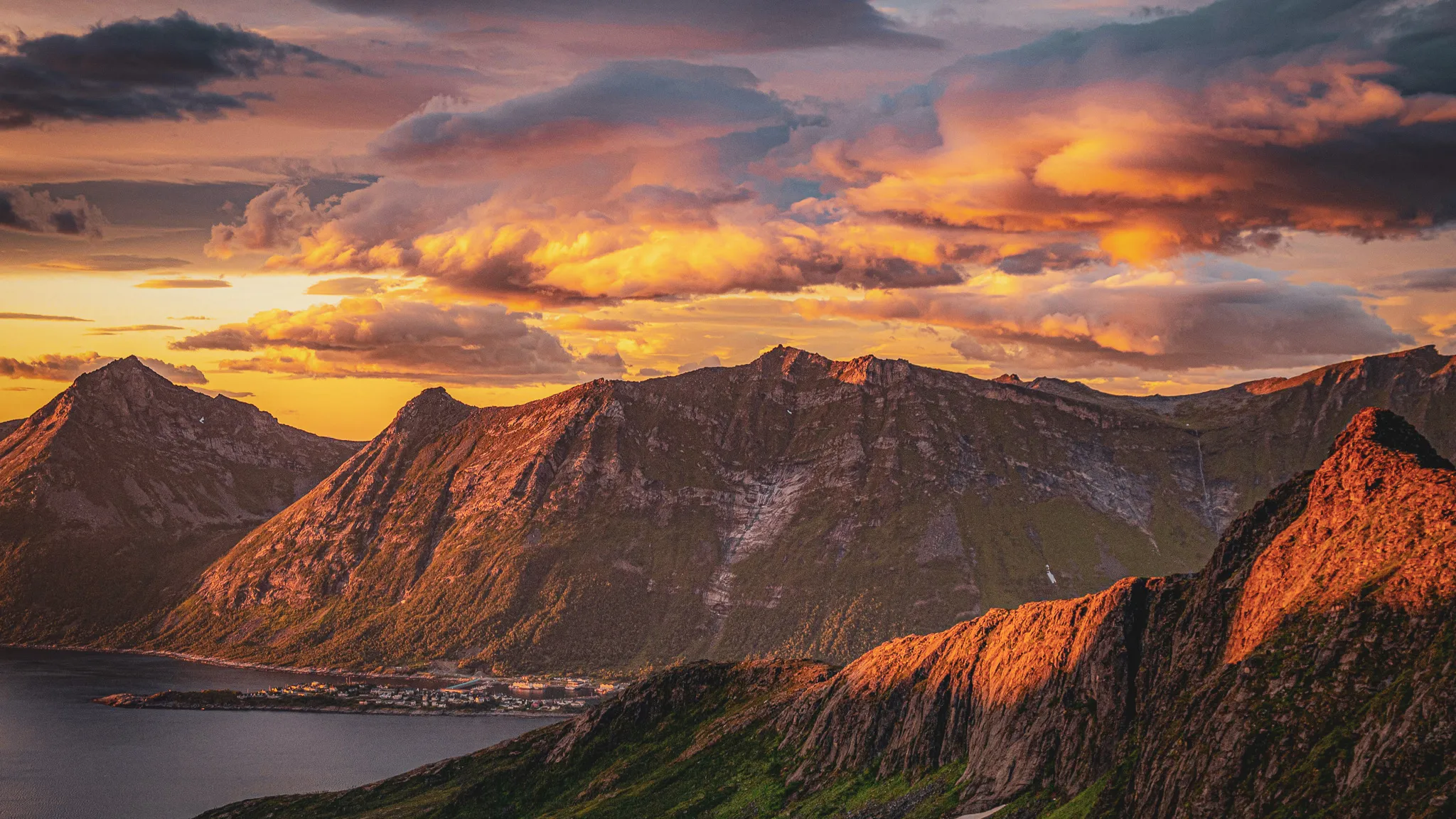Sunset over majestic mountains, surrounded by a tranquil fjord in Norway