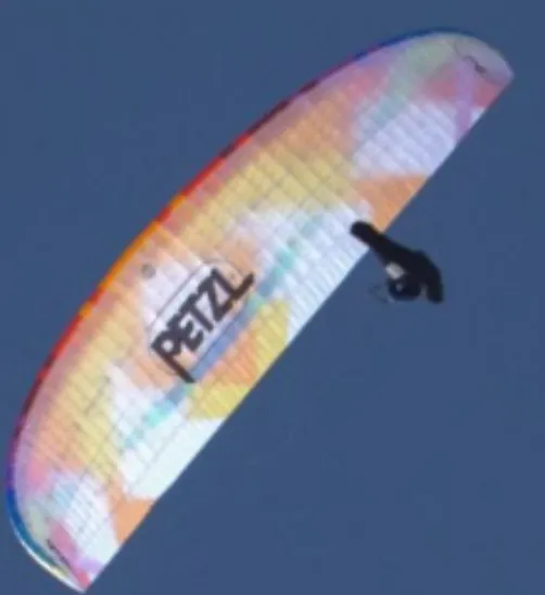 homme - Guillaume -  en parapente avec le logo du sponsor Petzl