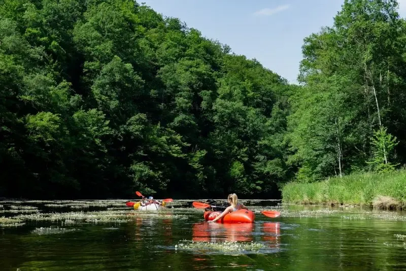 2 packrafts sur la semois entourés d'arbres