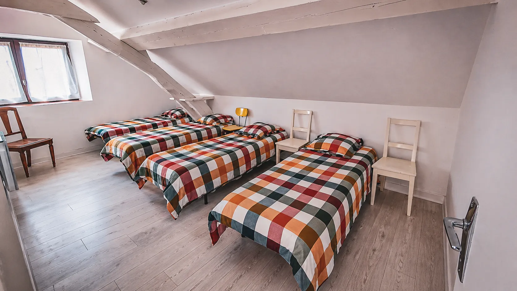 Cosy rooms with colourful checked beds, perfect for a stay in the Hauts Plateaux.