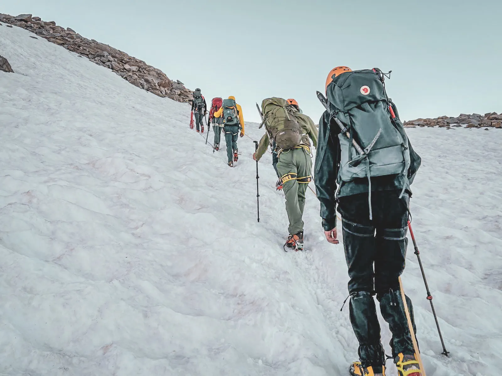 A group of mountaineers climbing a snowy slope toward the summit of Gran Paradiso