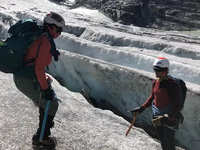 Guide de haute montagne avec une cliente sur un glacier