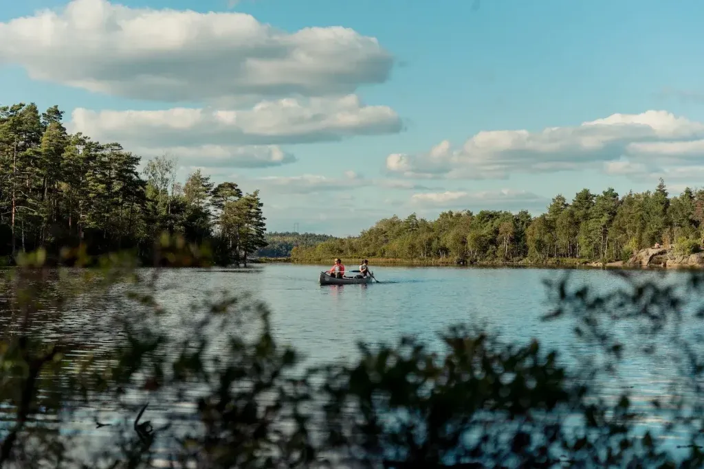 Deux personnes entrain de faire du canoë en Suède avec ciel bleu